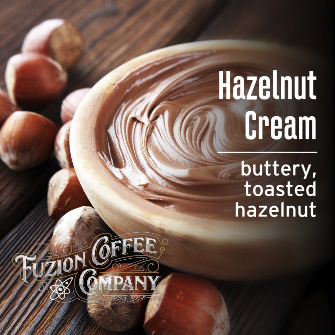 Hazelnut cream with hazelnuts on a wooden surface, featuring Fuzion Coffee Company branding.